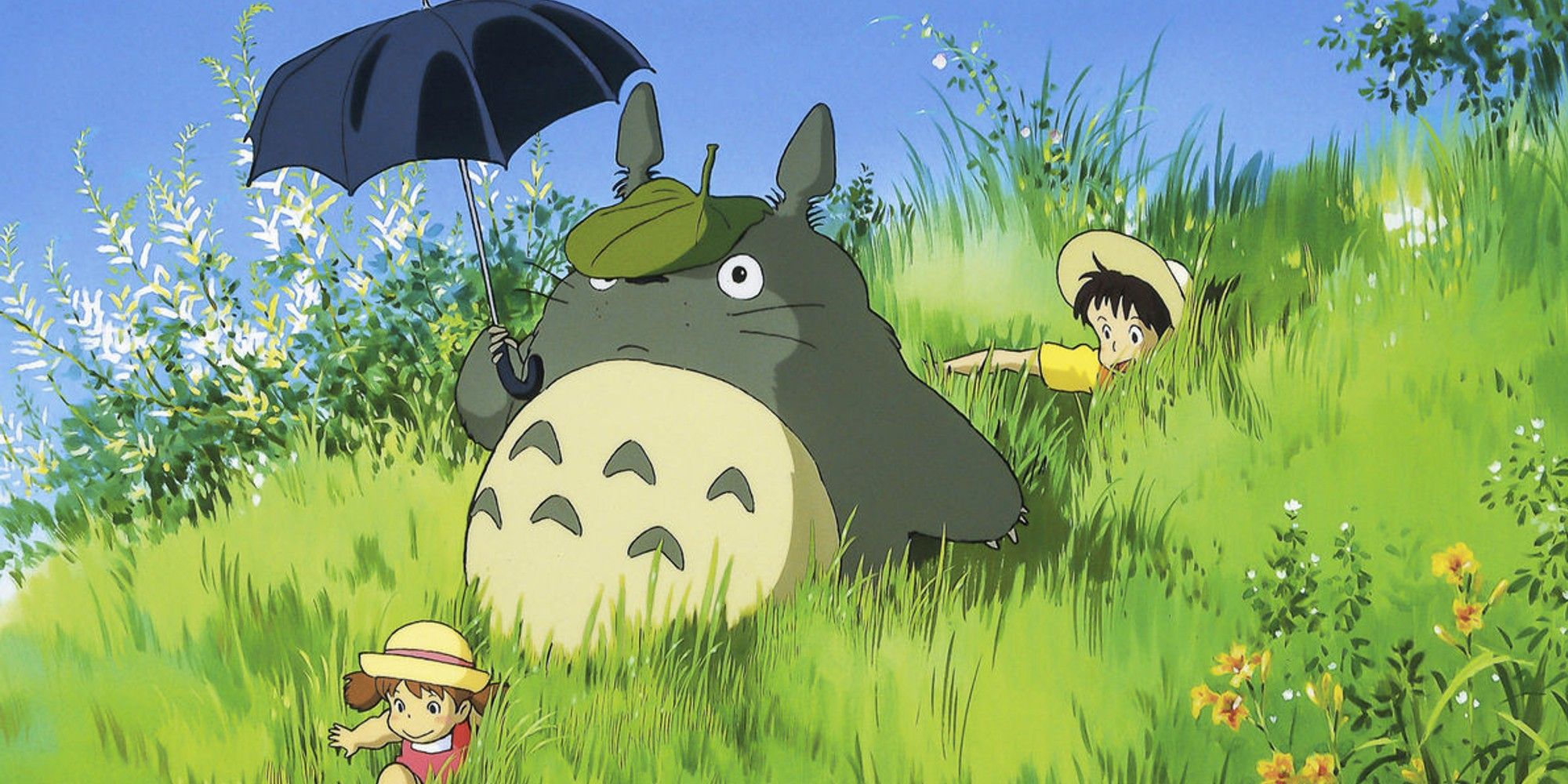 Totoro and the children sitting in a field in My Neighbour Totoro