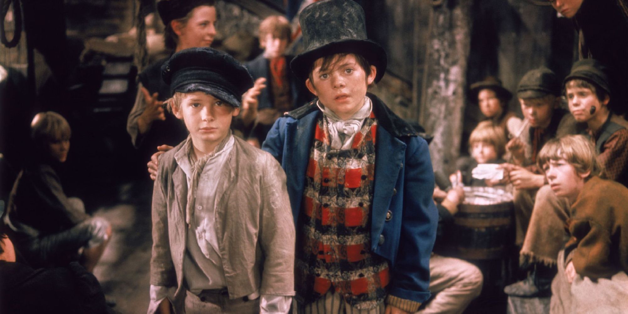 Oliver and another boy look off-camera with a hopeful expresison in the film Oliver!