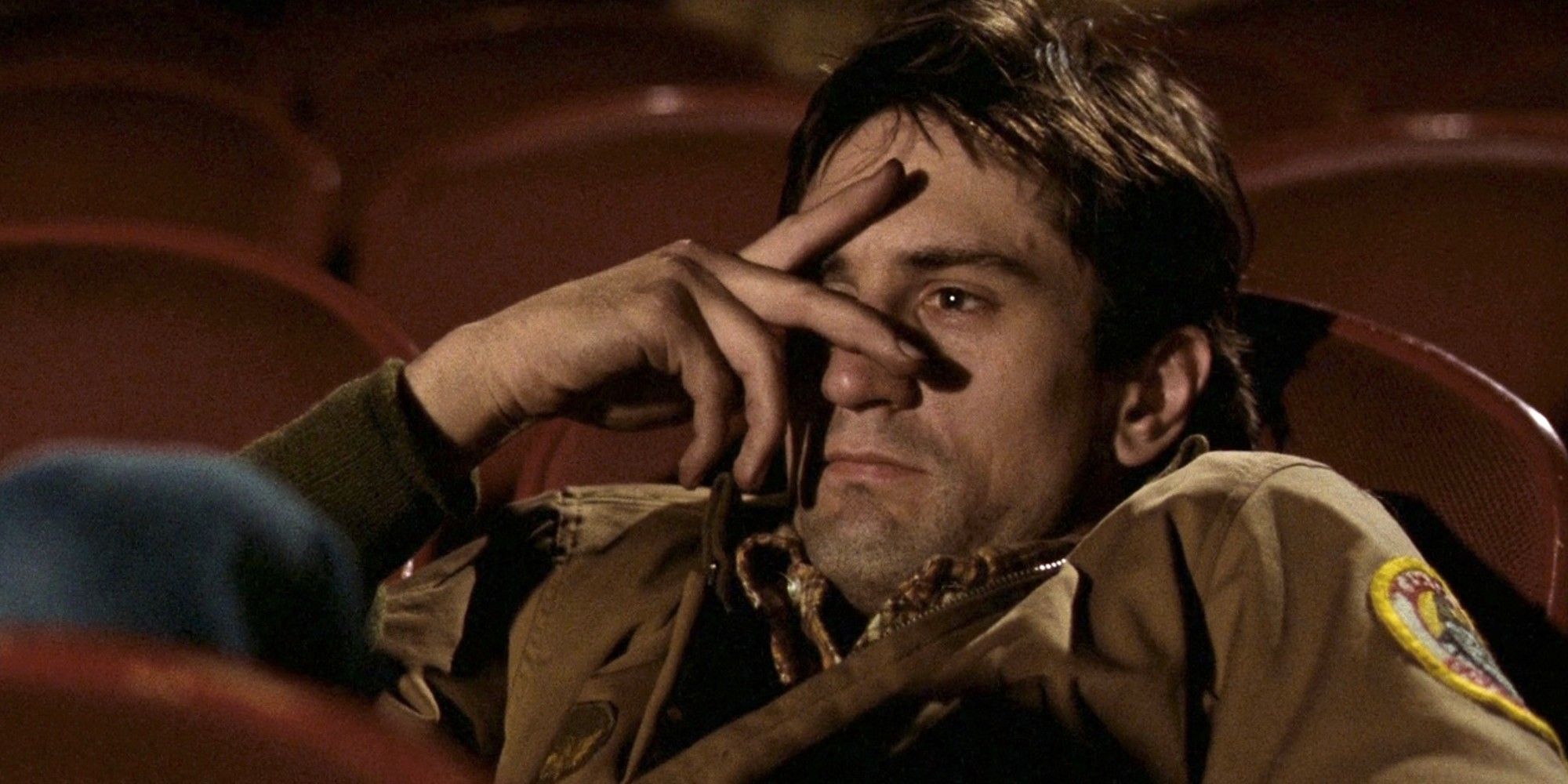 Travis Bickley at the movie theater with his hand half-covering his eyes in Taxi Driver.