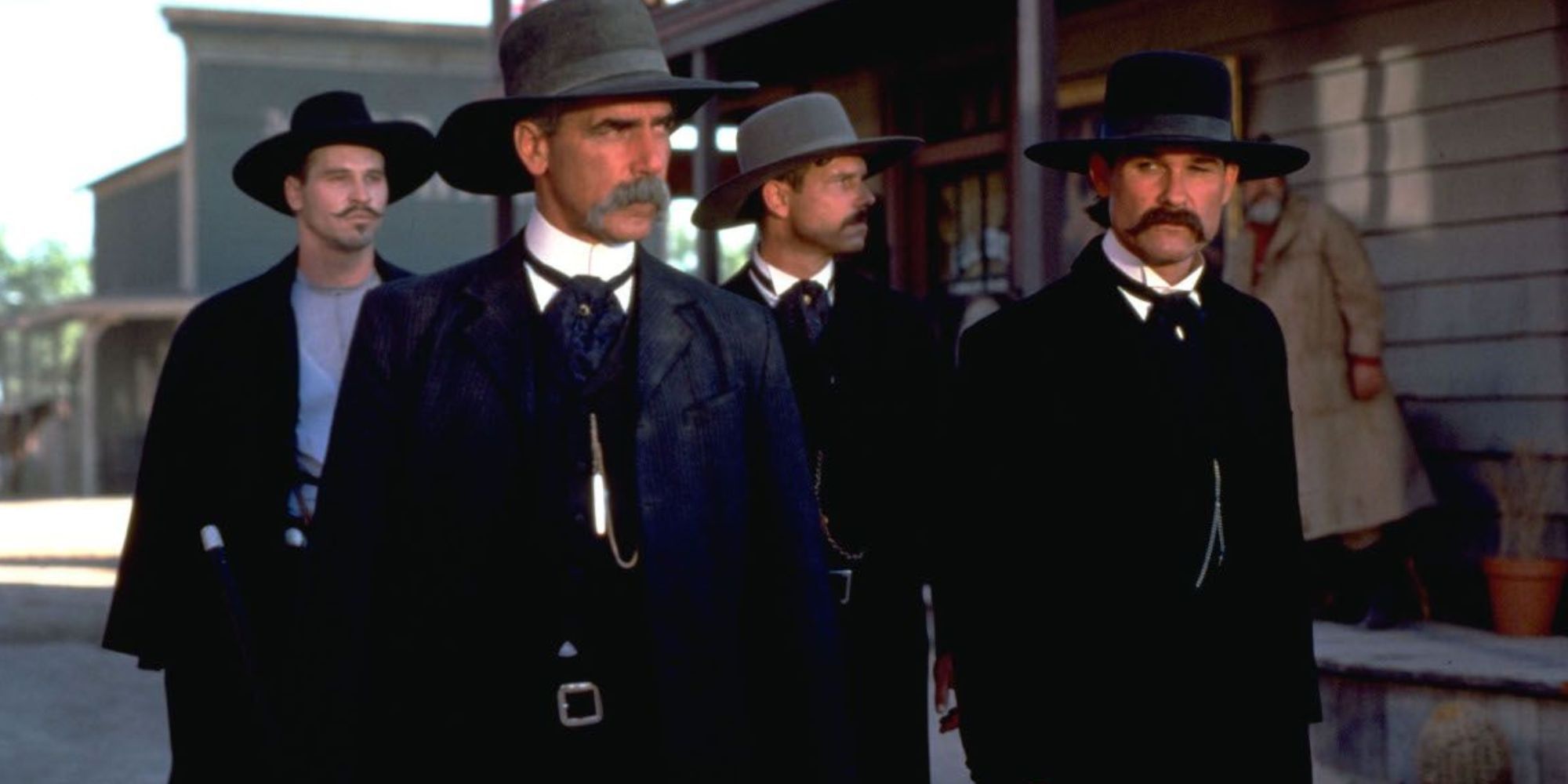 Sam Elliott et Kurt Russell debout l'un à côté de l'autre avec Val Kilmer et Bill Paxton derrière eux dans Tombstone.