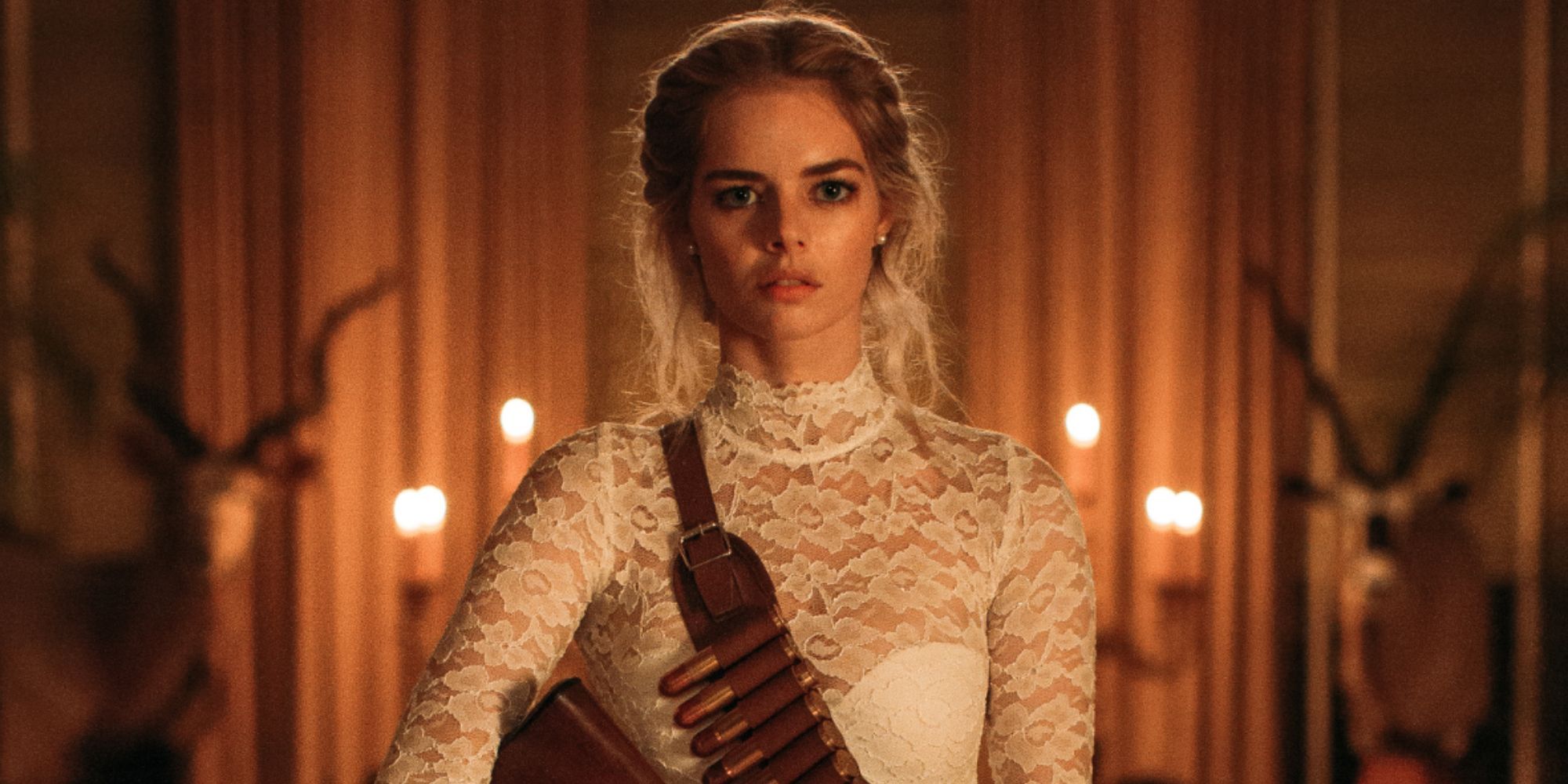 Samara Weaving as Grace wearing a wedidng dress and a bullet sash and holding a gun in Ready or Not