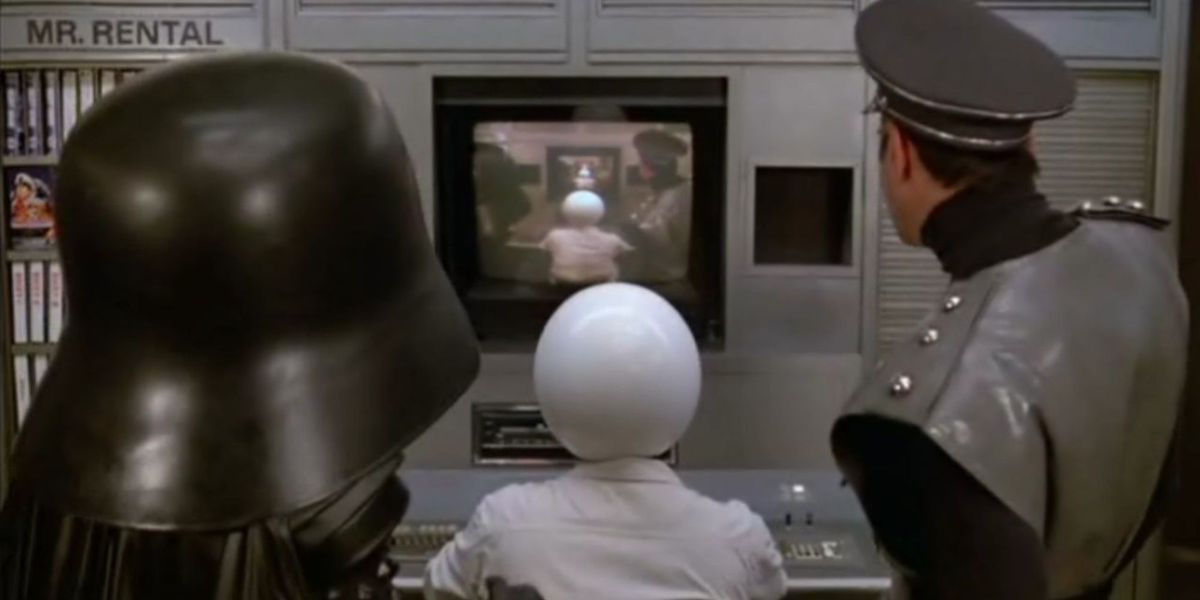Dark Helmet, Colonel Sandurz and Spaceball stare at the screen