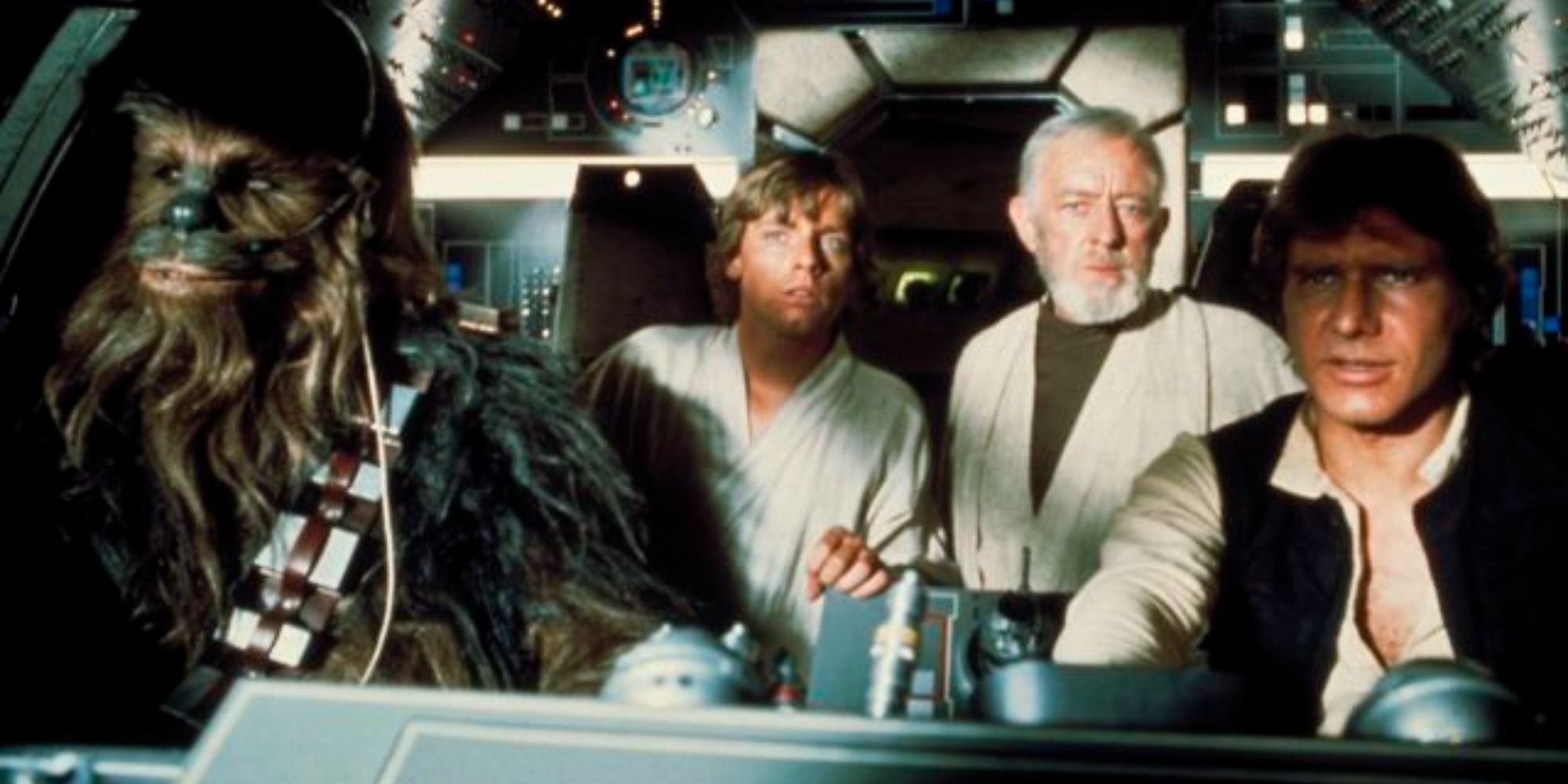 Chewbacca (Peter Mayhew), Luke Skywalker (Mark Hamill), Obi-Wan Kenobi (Alec Guinness), and Han Solo (Harrison Ford) sitting in the cockpit of the Millenium Falcon in Star Wars: Episode IV – A New Hope.