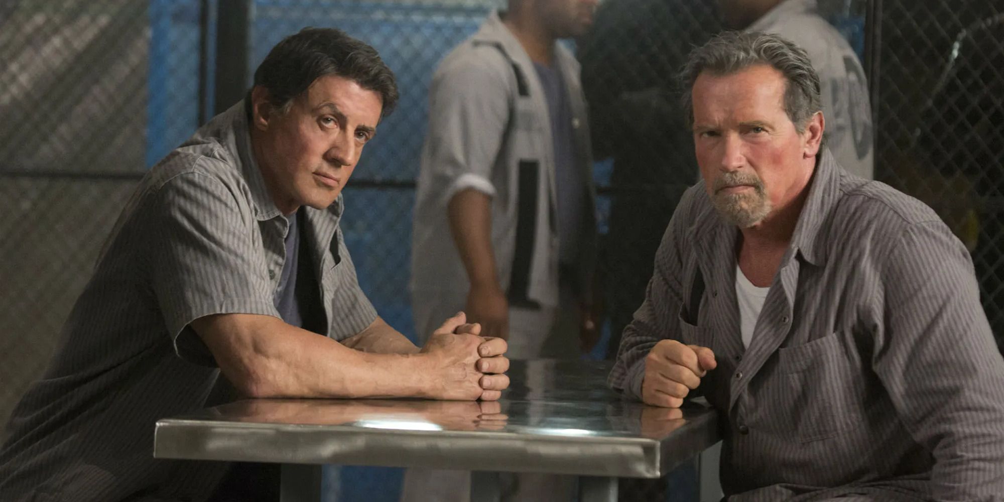 two inmates sitting at a metal table