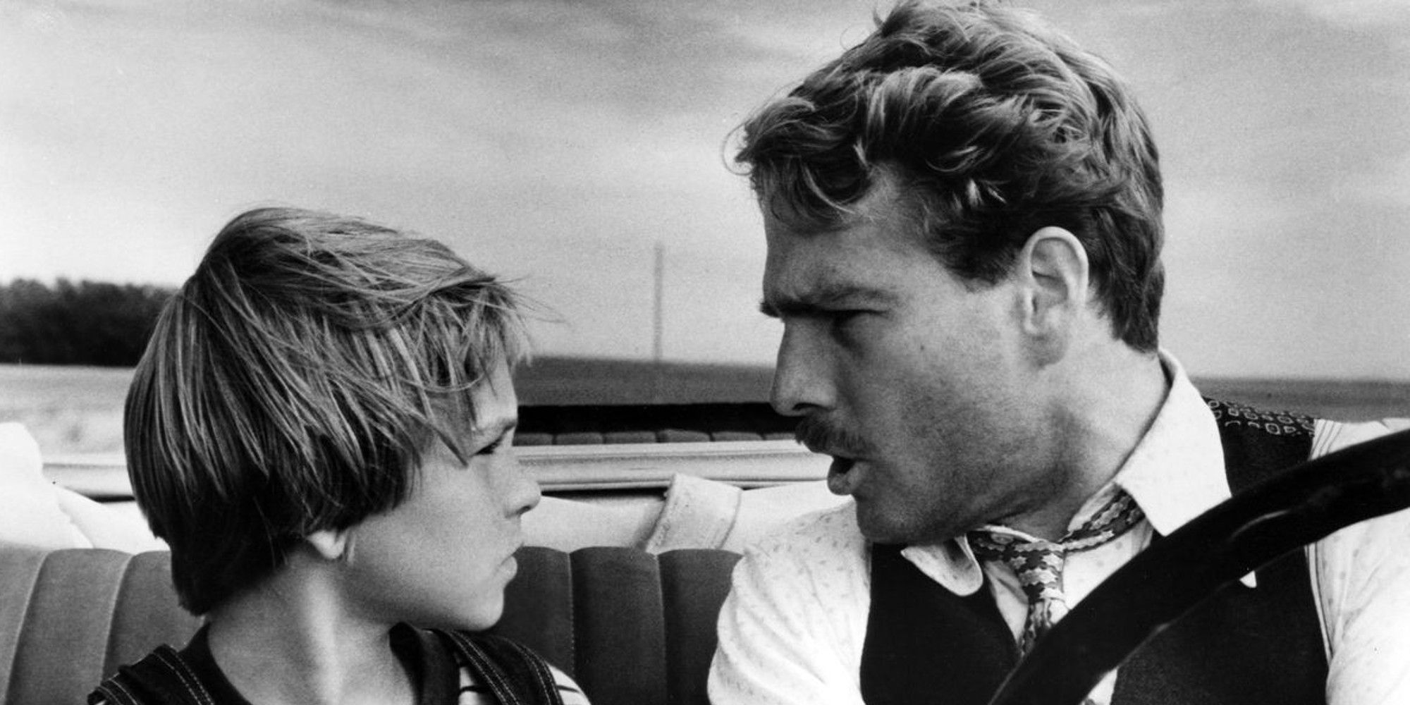 Moses and Addie looking at each other inside a car in 'Paper Moon'