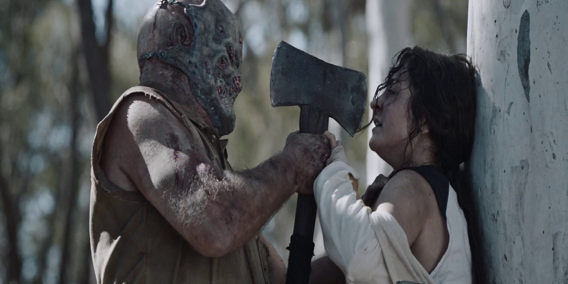 A masked killer holding an axe to a woman's face