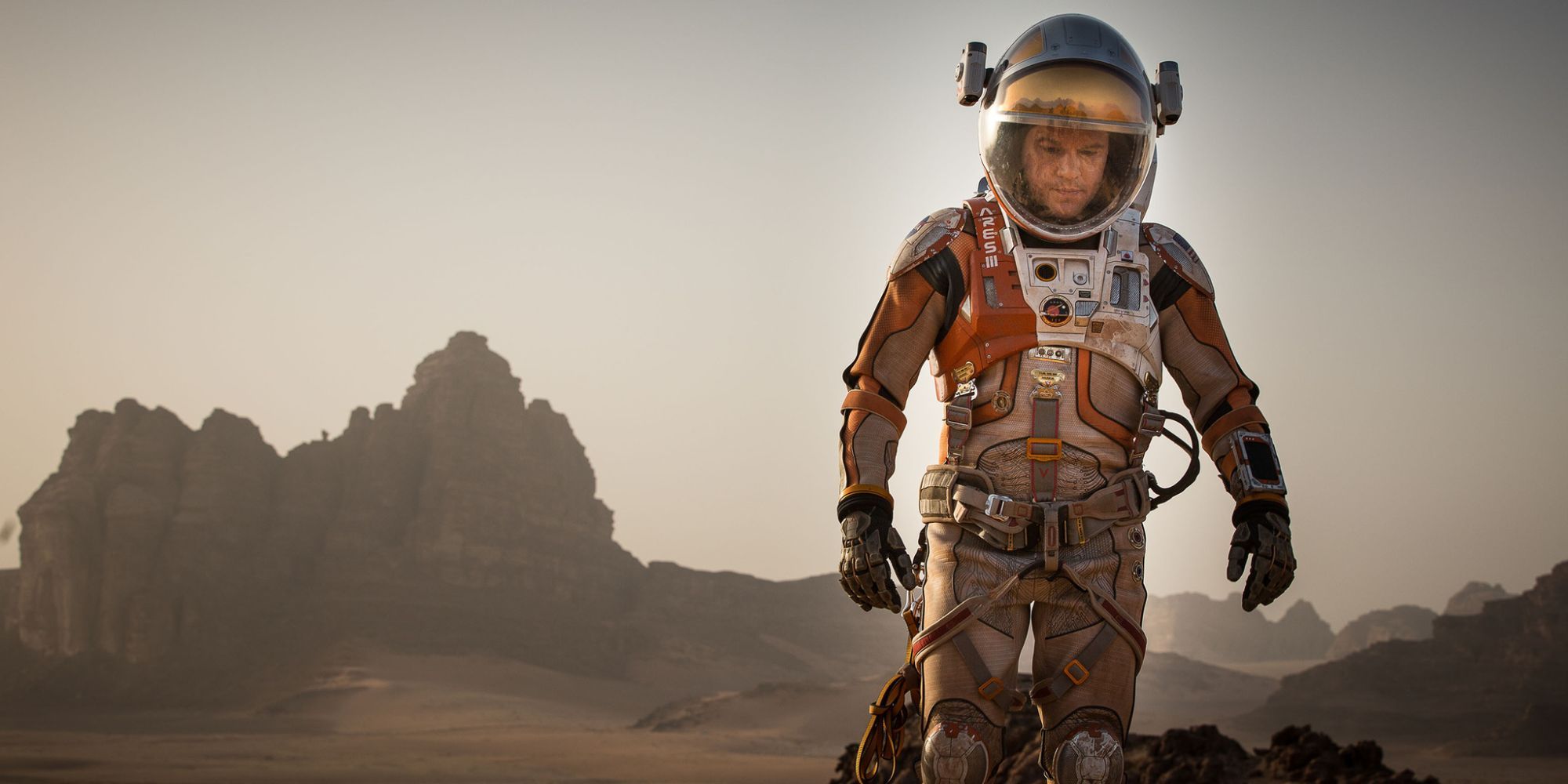 Matt Damon as Mark Watney wearing a space suit on Mars in The Martian.