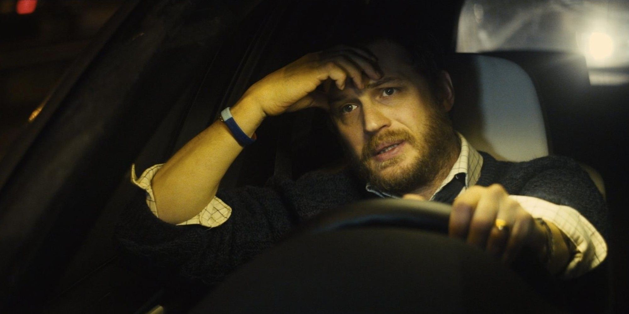 Tom Hardy as Ivan Locke looking worried while driving a car in 'Locke'