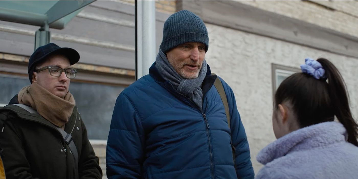 Woody Harrelson in a blue beanie talking to a girl in a purple ponytail in CHampions