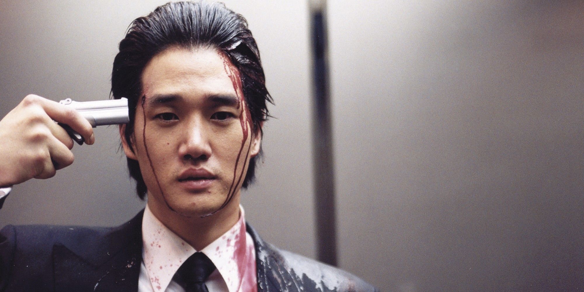 Yoo Ji-tae with a gun pointed at his head in 'Oldboy'