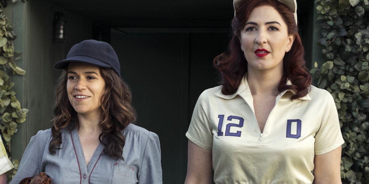 Abbi Jacobson as Carson and D'Arcy Carden as Greta standing together in the baseball field in 'A League of Their Own' (2022)