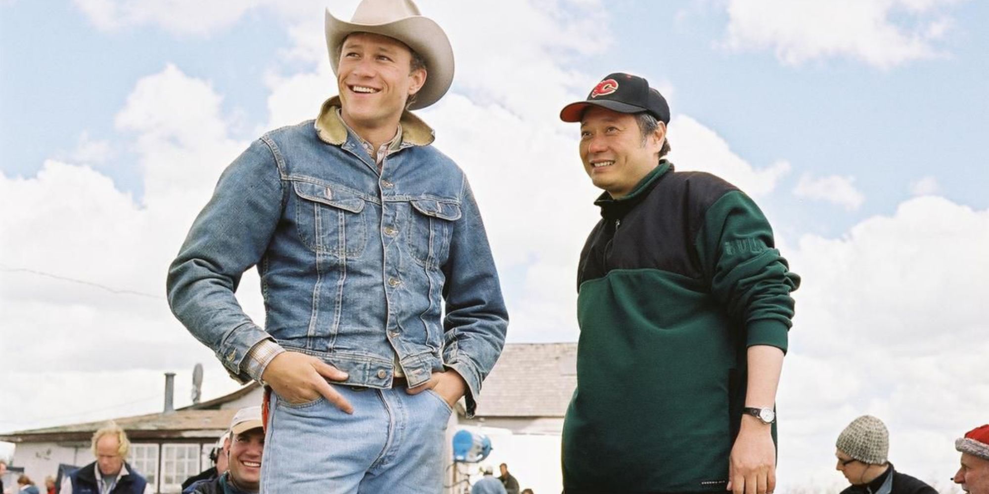 Two men standing on outdoor set with more people in the background