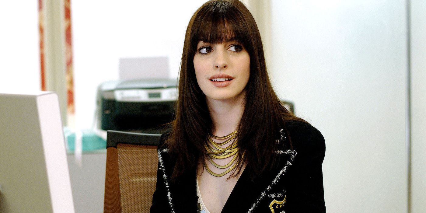 Anne Hathaway assise à un bureau dans le rôle d'Andy dans Le Diable s'habille en Prada