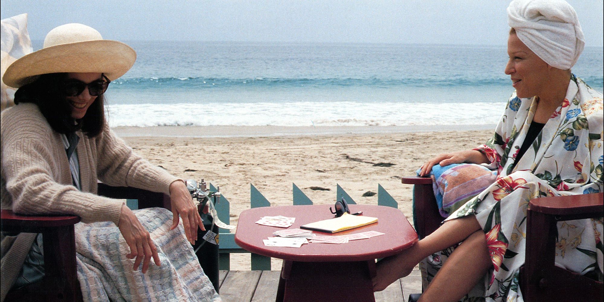 Bette Midler as C.C. and Barbara Hershey as Hillary sitting together in Beaches