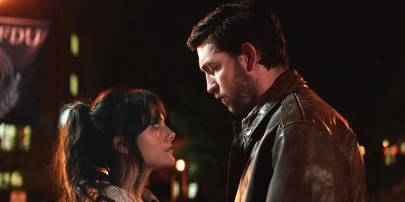 A man and a woman standing on the street at night and looking at each other in the film Cat Person.