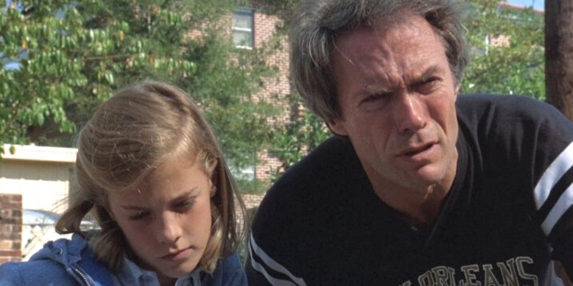 Clint Eastwood se penche sur une fenêtre de voiture ouverte et regarde quelqu'un avec une fille à côté de lui dans Tightrope.
