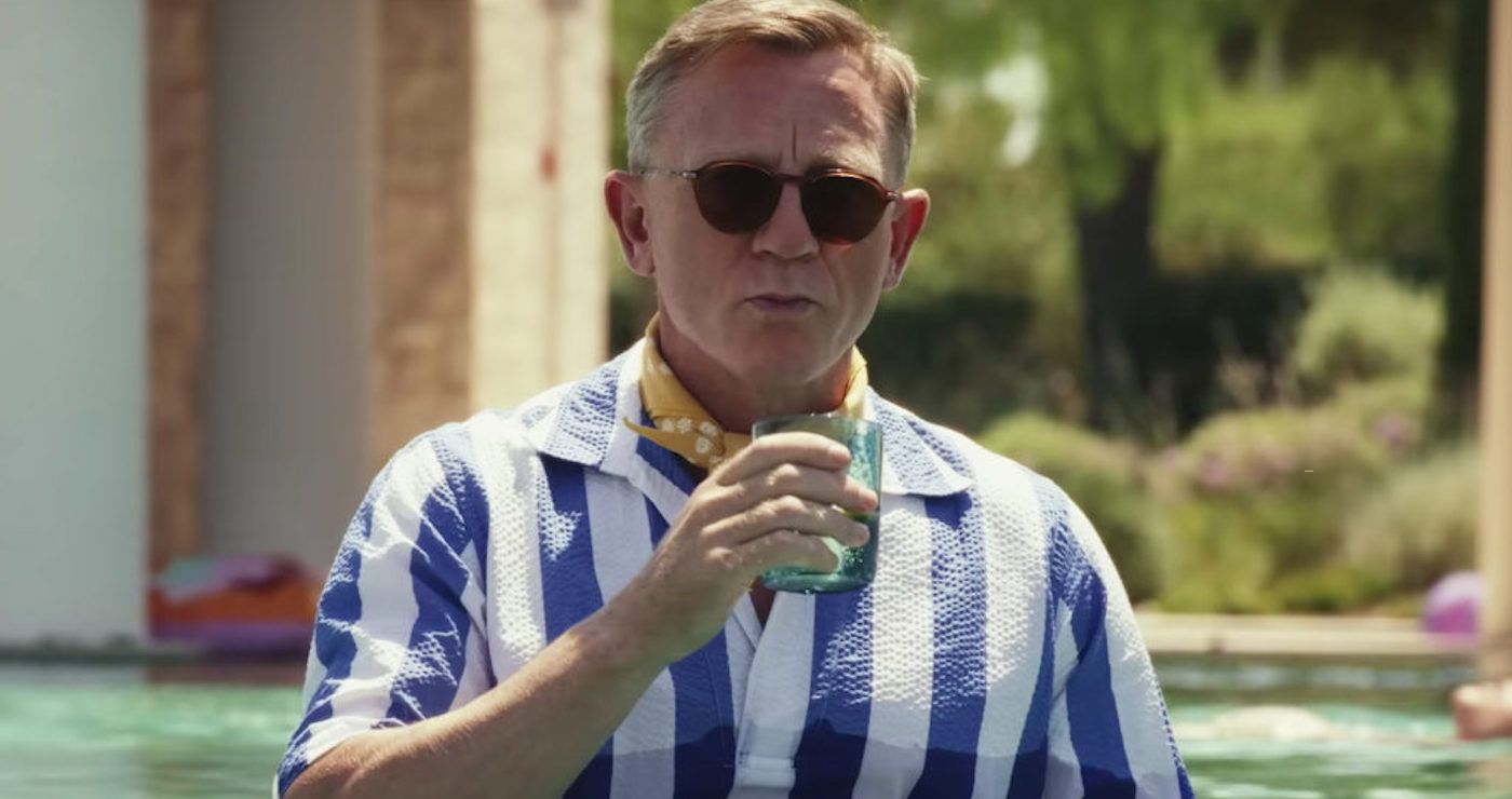 Daniel Craig dans le rôle de Benoit Blanc tenant un verre dans la piscine dans Glass Onion
