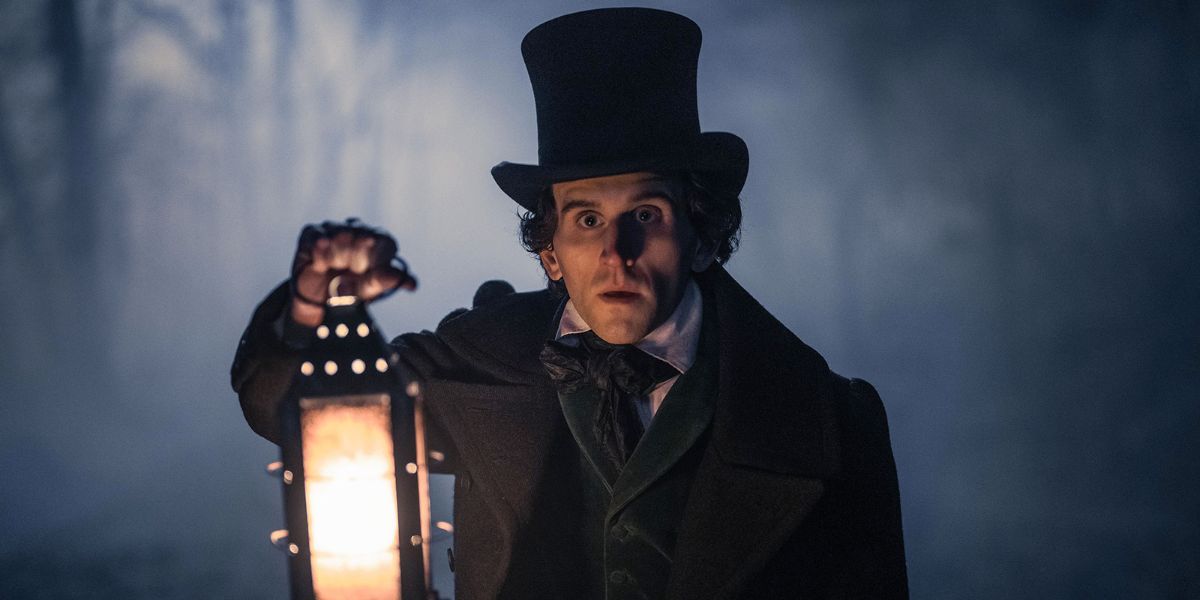 Edgar Allan Poe, interpretado por Harry Melling, segurando uma lâmpada no escuro em 'The Pale Blue Eye'.