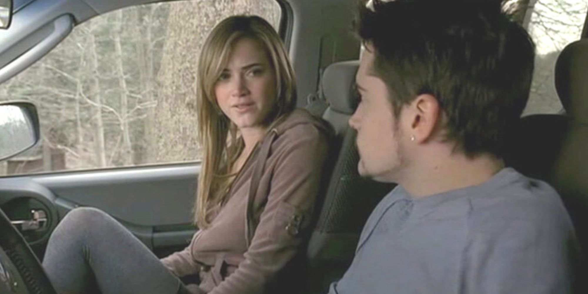 Emily Wickersham senta no banco do passageiro de um carro assistindo AJ em The Sopranos