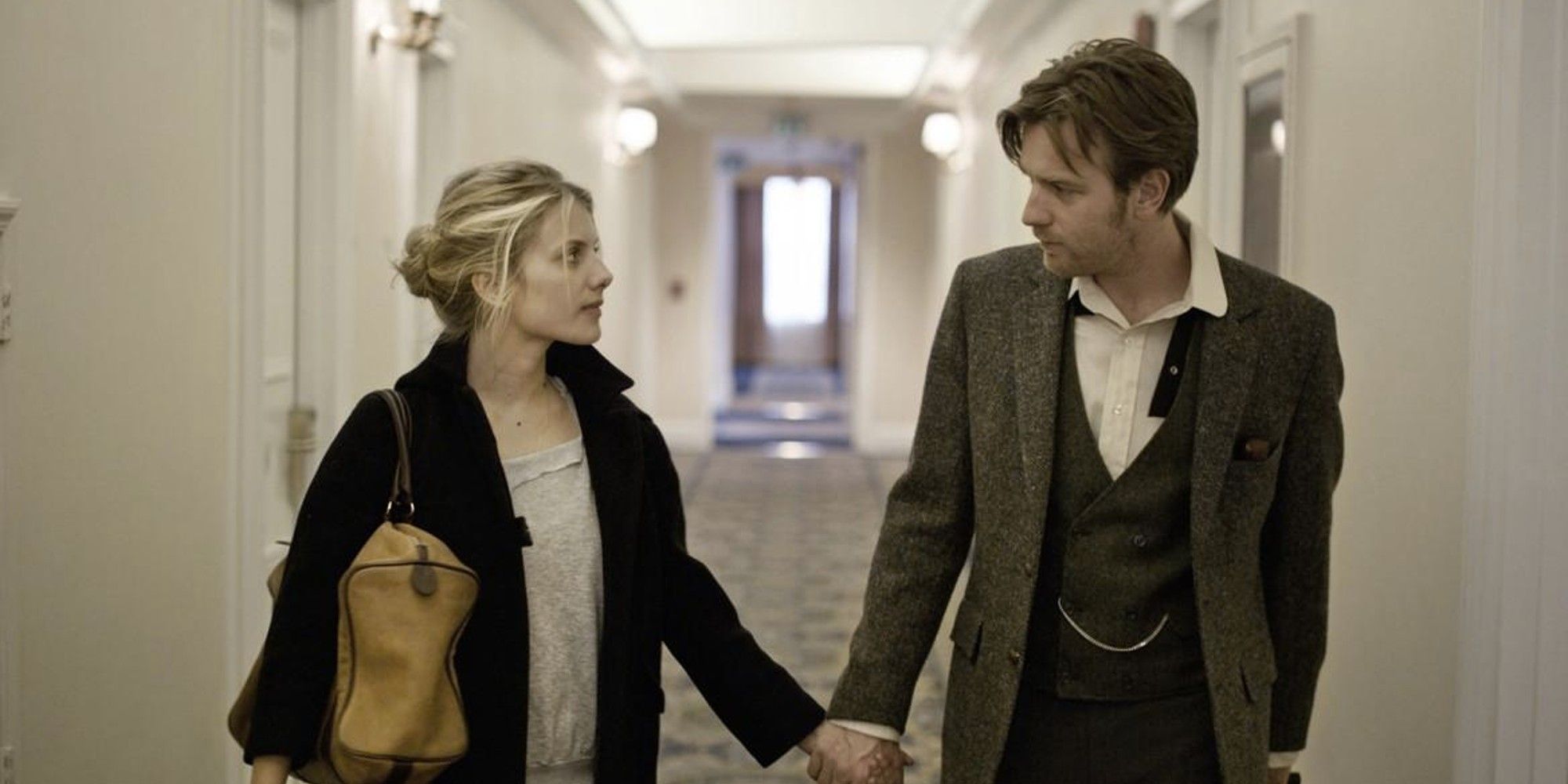 Ewan McGregor and  Mélanie Laurent in 'Beginners' looking at each other while holding hands.