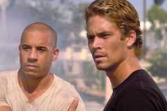 Vin Diesel and Paul Walker in The Fast and the Furious looking at something off-camera. 