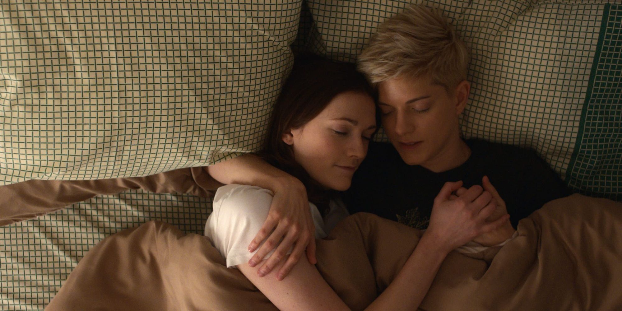Mae Martin and Charlotte Ritchie as Mae and George in bed together in the Netflix series Feel Good.
