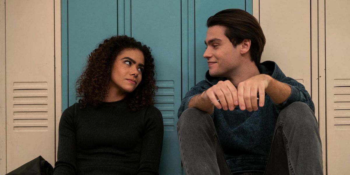 Antonia Gentry as Ginny Miller and Felix Mallard as Marcus Baker sitting against the lockers in Season 2 of Ginny and Georgia