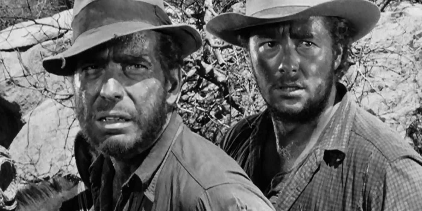 Humphrey Bogart sebagai Dobbs dan Tim Holt sebagai Curtin dalam The Treasure of the Sierra Madre