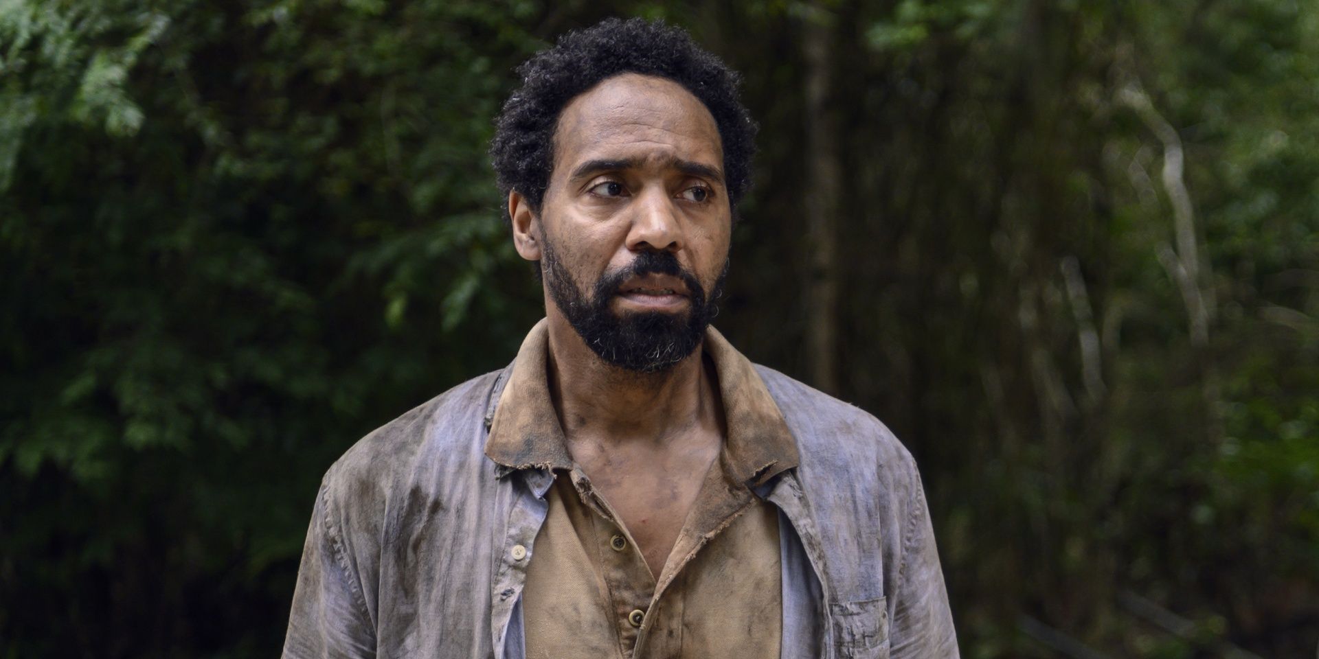 Virgil, a rugged survivor of the zombie apocalypse, stands in the woods in'The Walking Dead'.