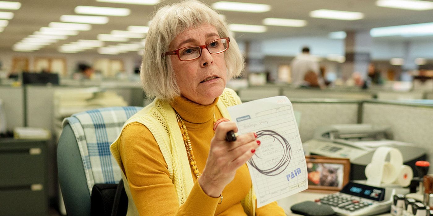 Jamie Lee Curtis as IRS Auditor Deirdre Beaubeirdre, holding up a form and looking frustrated in Everything Everywhere All At Once