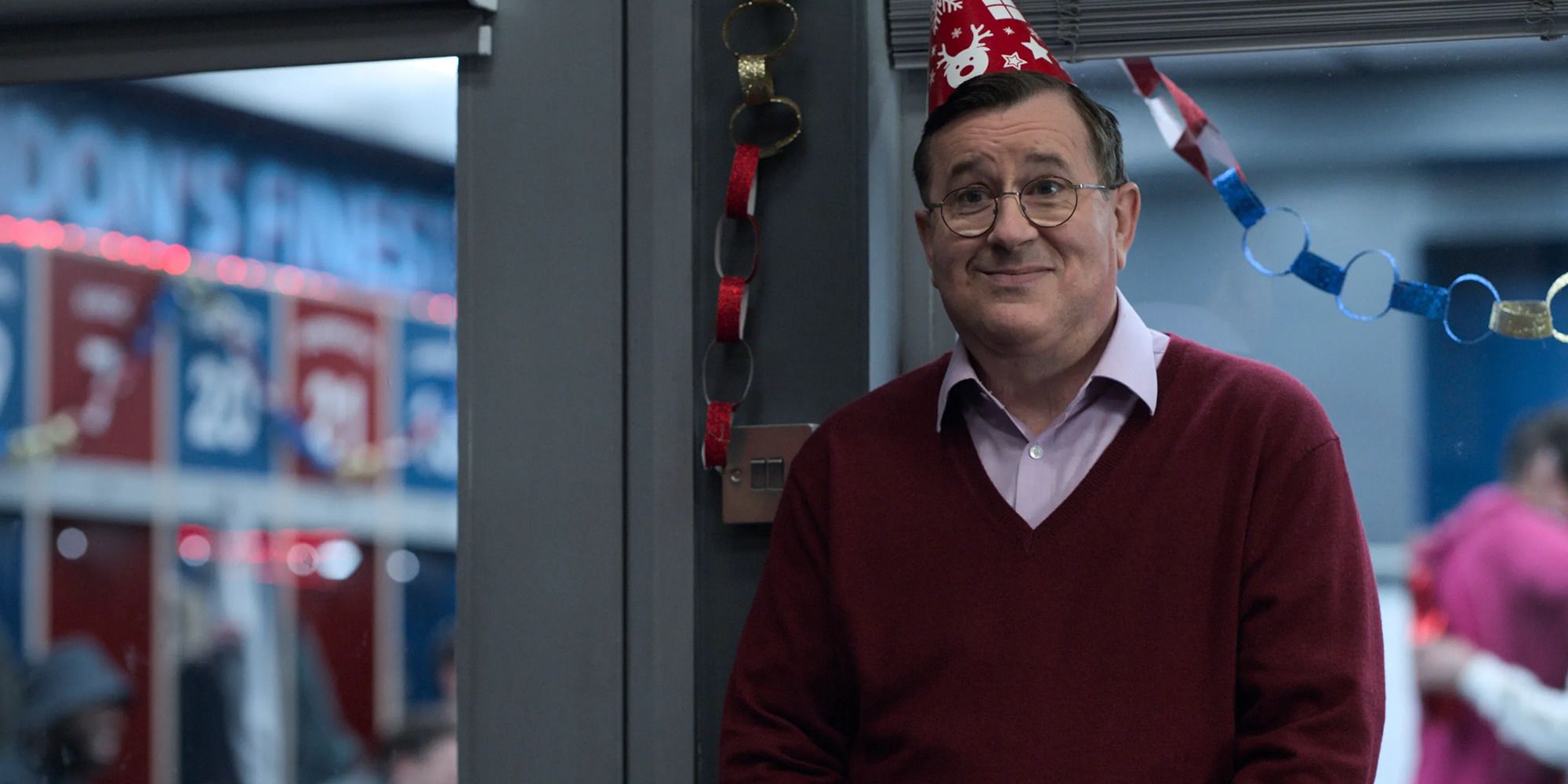 a man with a sweater, party hat, and awkward expression