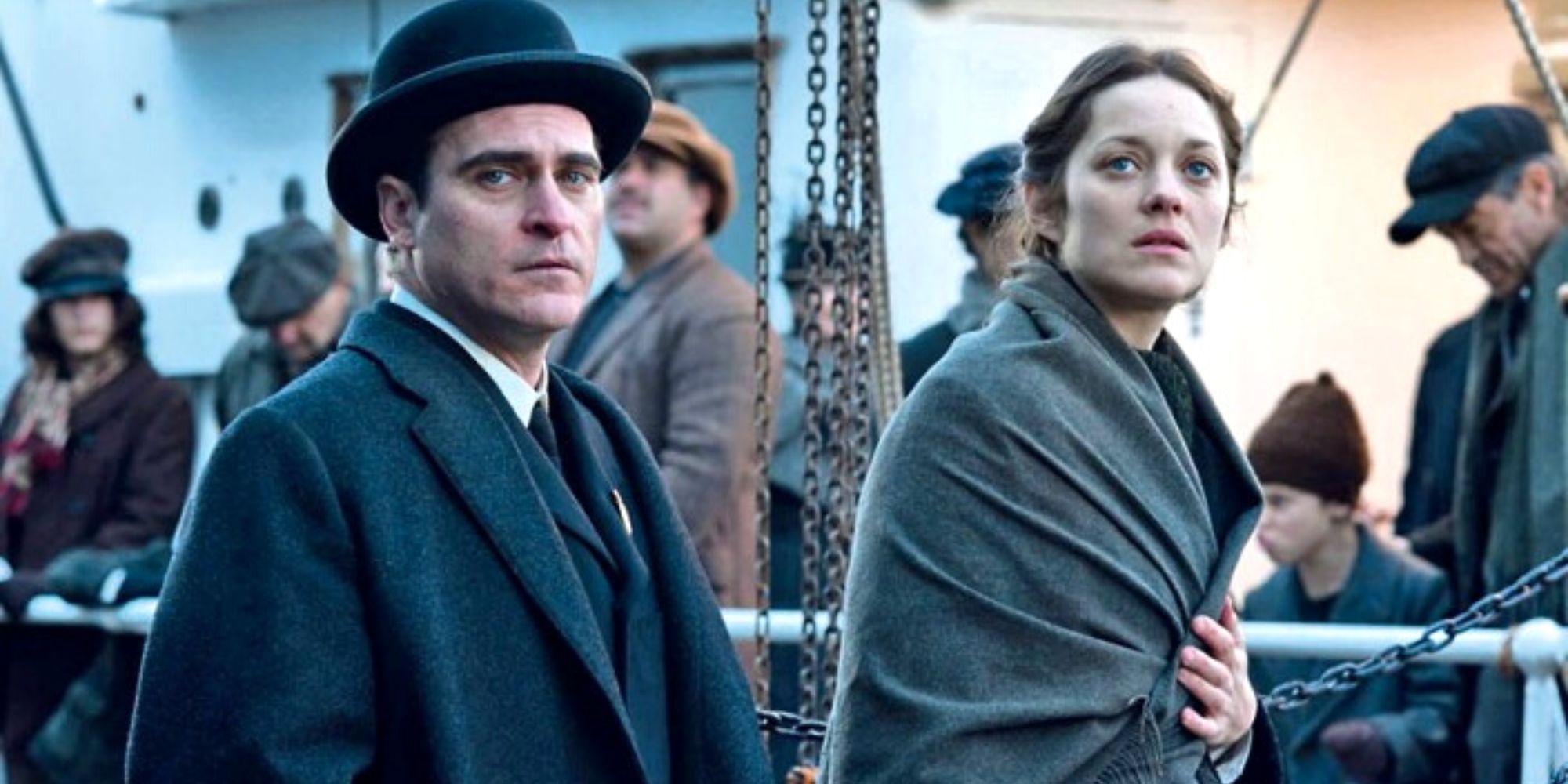 Joaquin Phoenix standing next to Marion Cotillard on a crowded ship in The Immigrant 