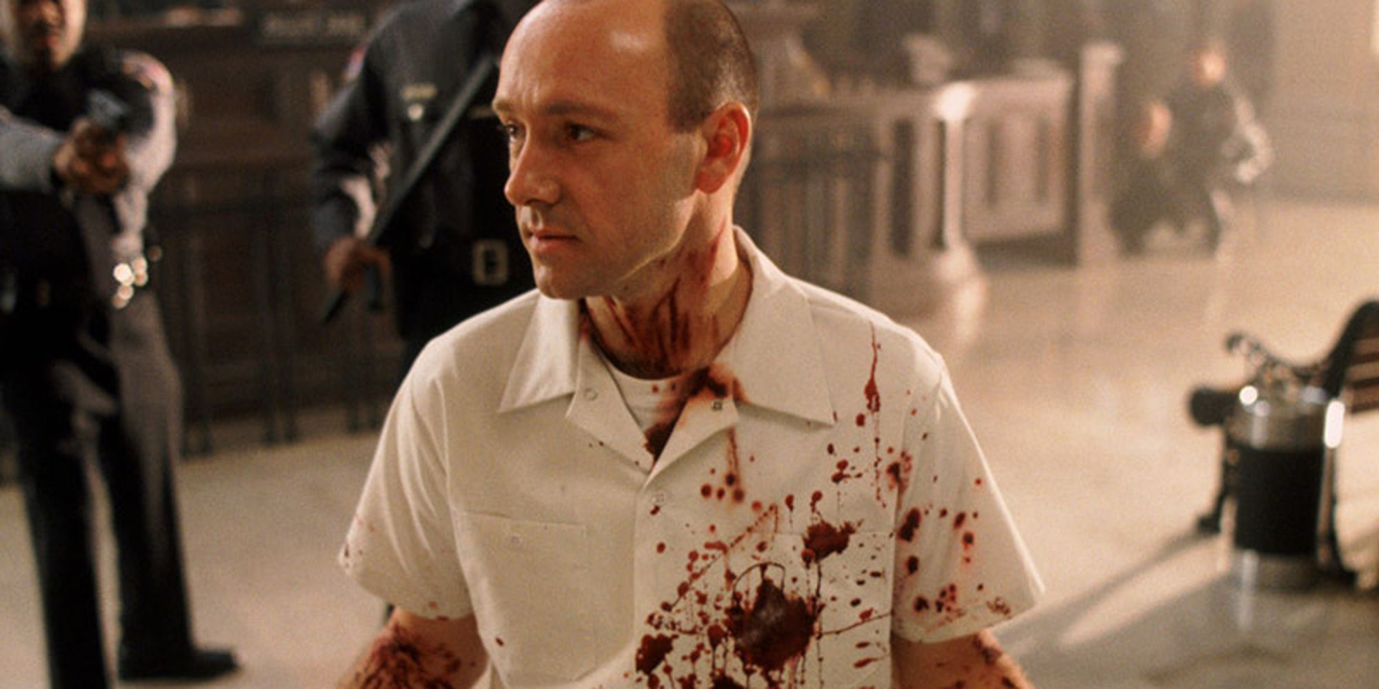 man with bloodied white shirt surrounded by cops