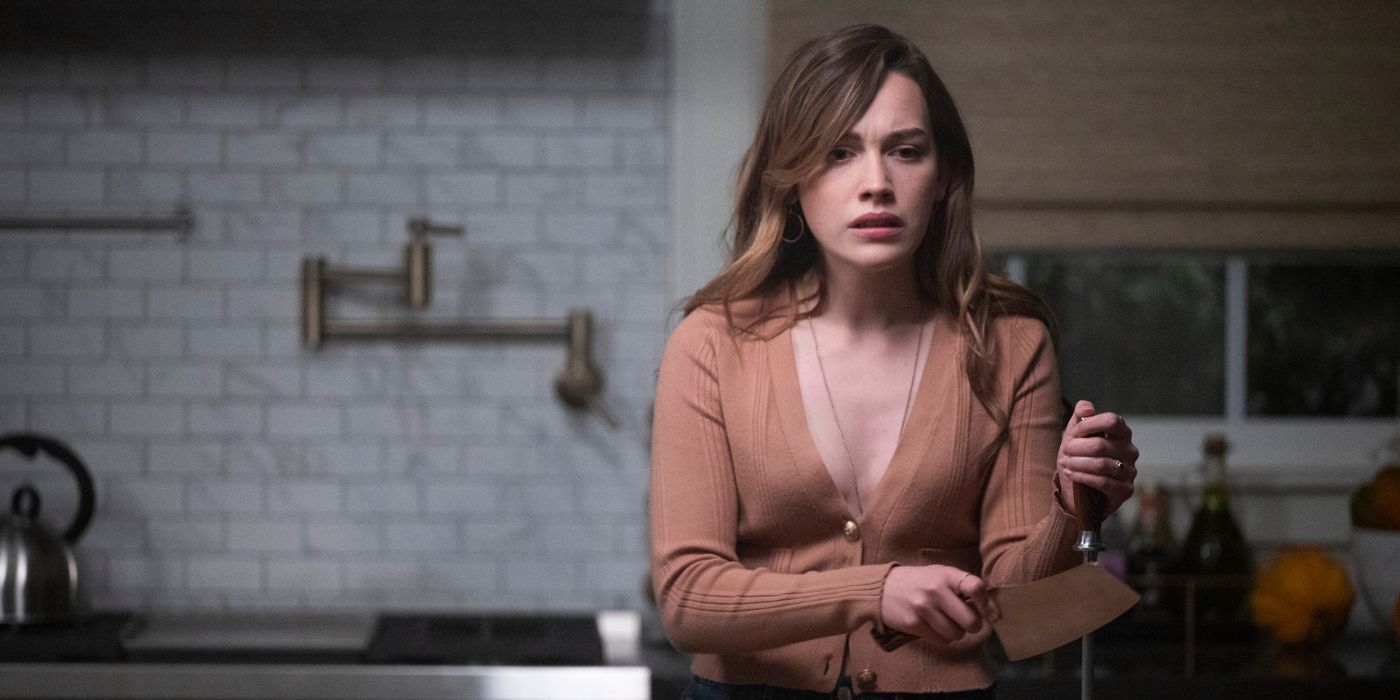 Love Quinn, played by Victoria Pedretti, looking upset as she sharpens her knife in the 'You' Season 3 finale.