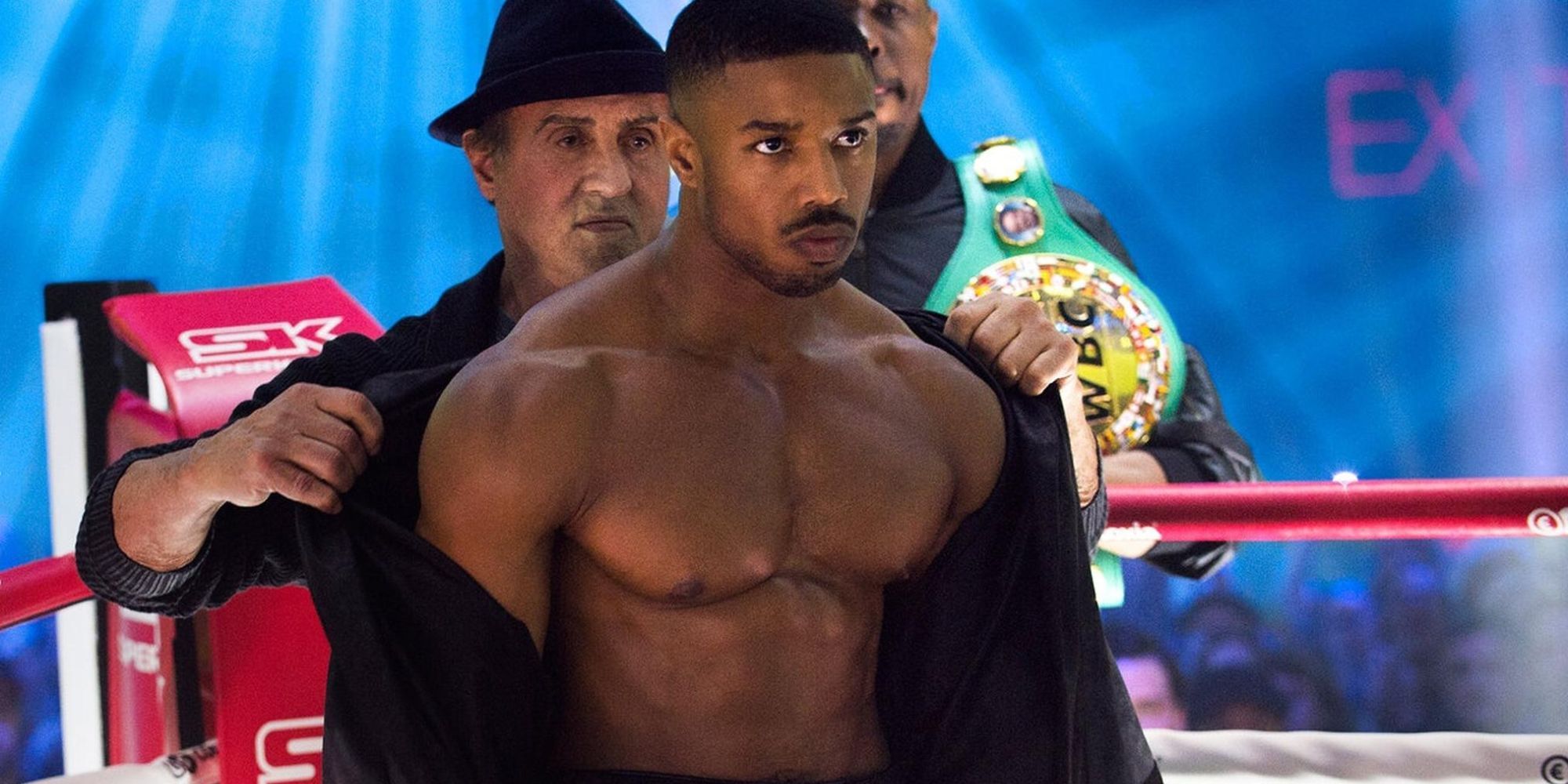 Michael B. Jordan in the boxing ring preparing to fight as Sylvester Stallone stands behind him in Creed II