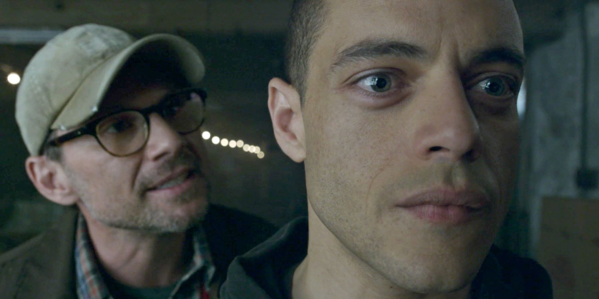 Christian Slater as Mr. Robot talks to Rami Malek as Elliot Alderson from behind in Mr. Robot.