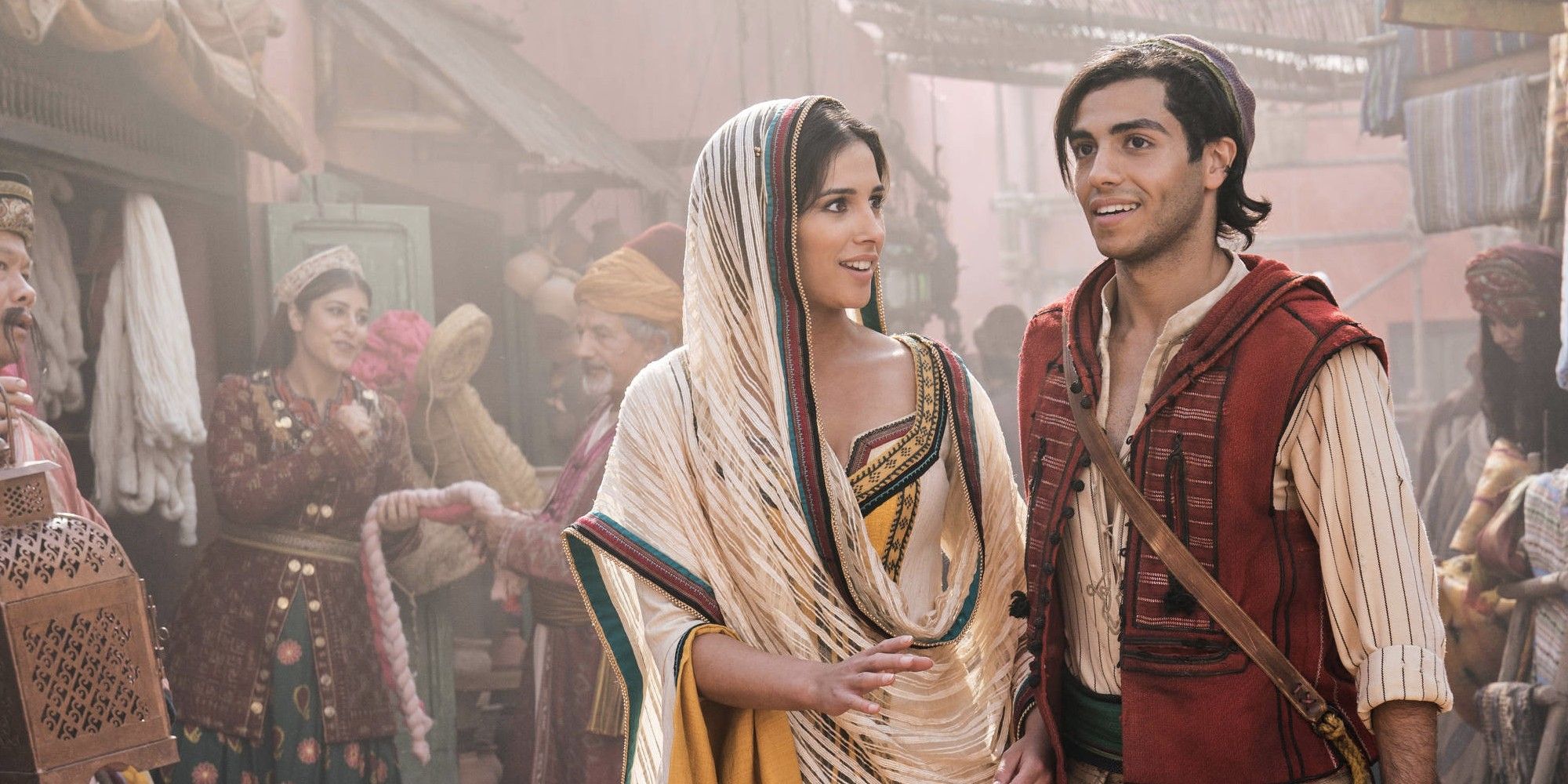 Naomi Scott as Jasmine smiling and looking at Mena Massoud as Aladdin in 'Aladdin'.