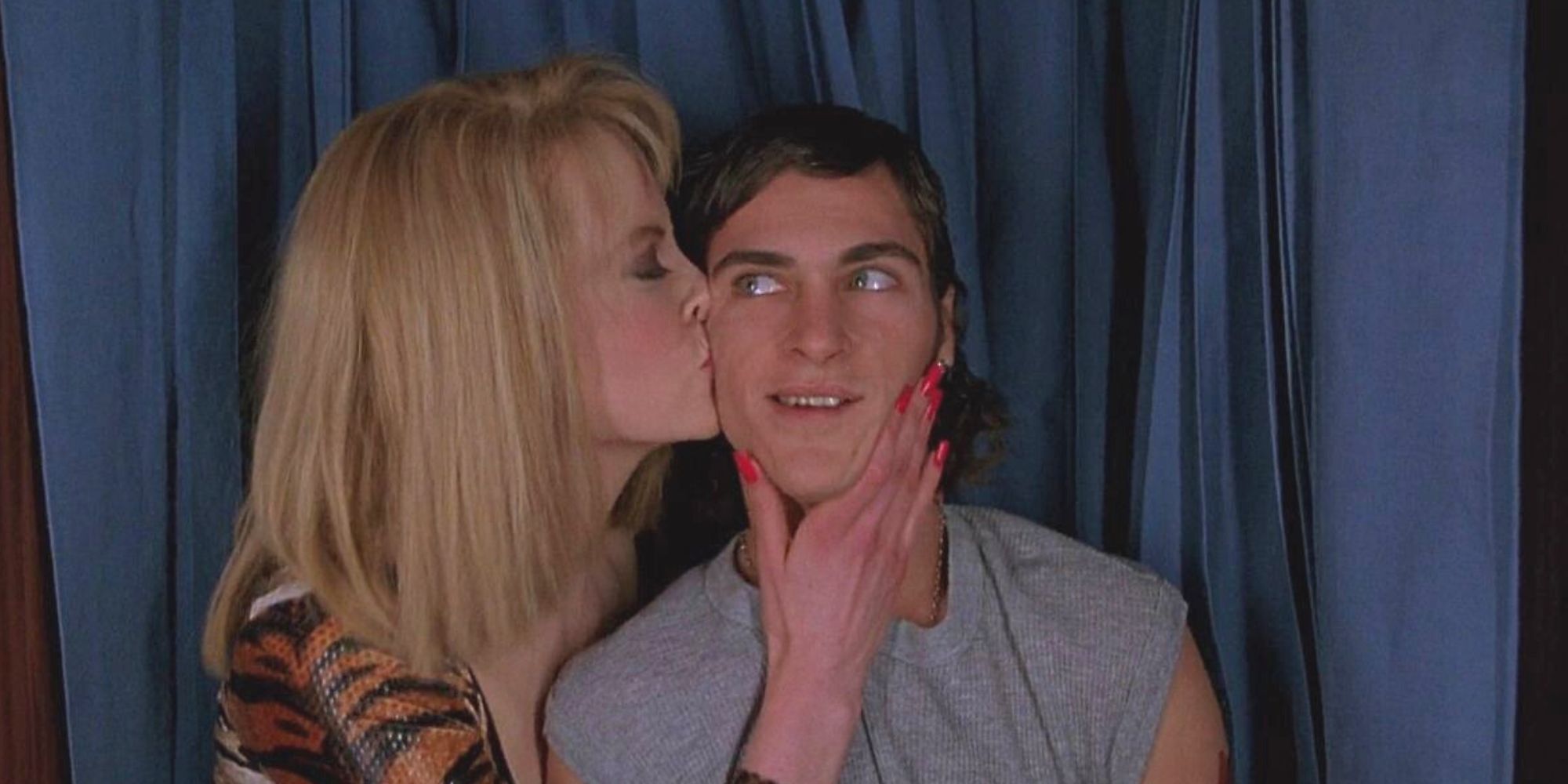 Nicole Kidman kissing Joaquin Phoenix on the cheek in a photo booth in To Die For