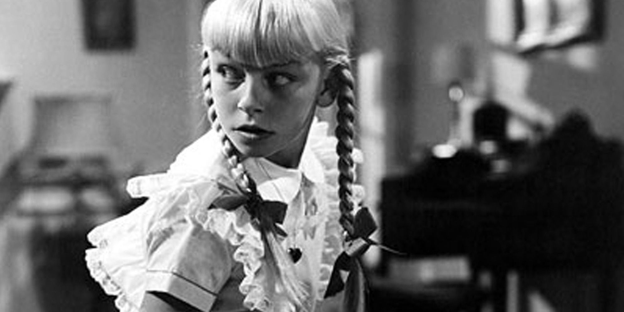 Patty McCormack as a blonde girl with two brains looking back in The Bad Seed.