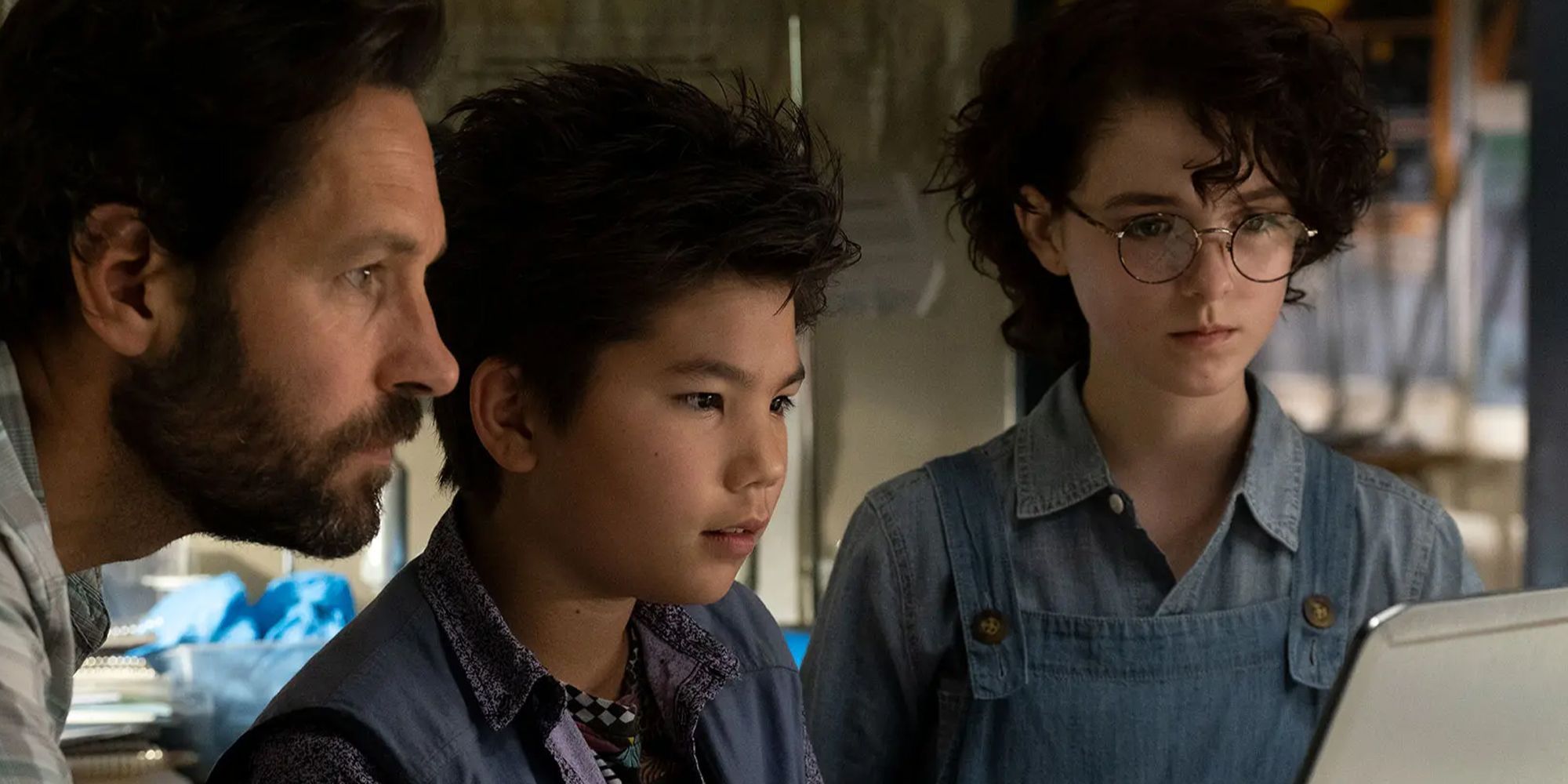 Paul Rudd, Logan Kim et McKenna Grace à côté les uns des autres, tous regardant un écran d'ordinateur dans Ghostbusters : Afterlife
