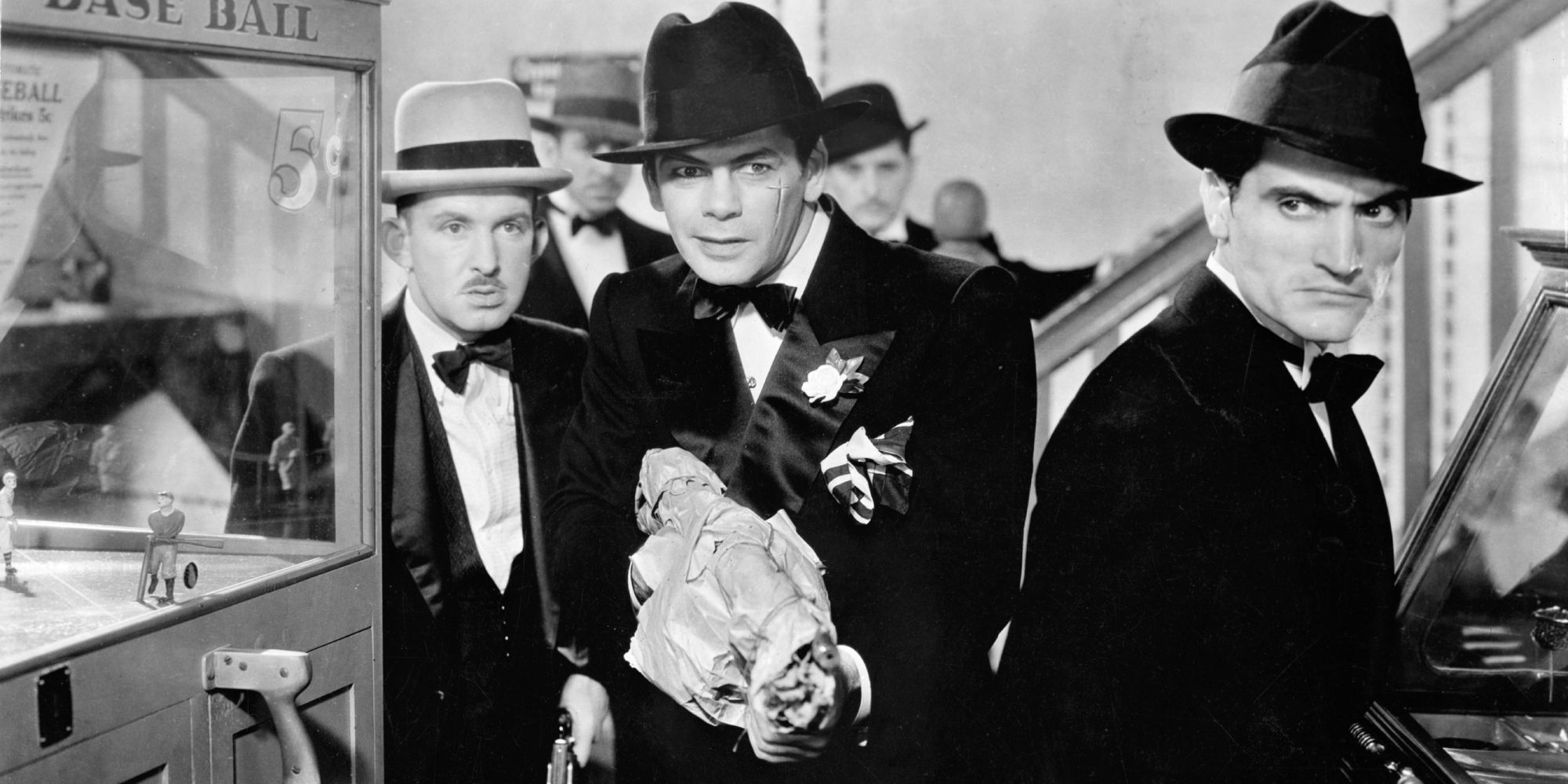 Paul Muni as Tony Camonte surrounded by men in Scarface - 1932