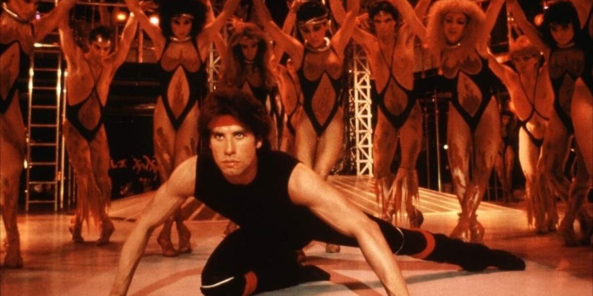 John Travolta dikelilingi oleh para penari