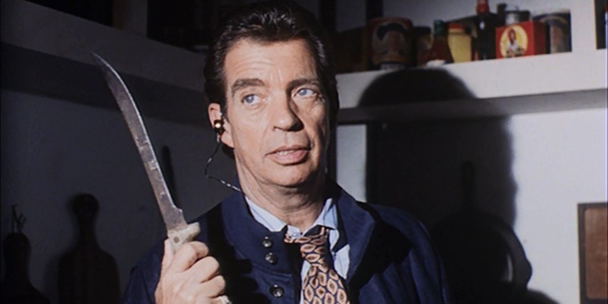 Horton Rivers, played by Morton Downey Jr., holds up a knife in Tales From the Crypt episode "Television Terror."