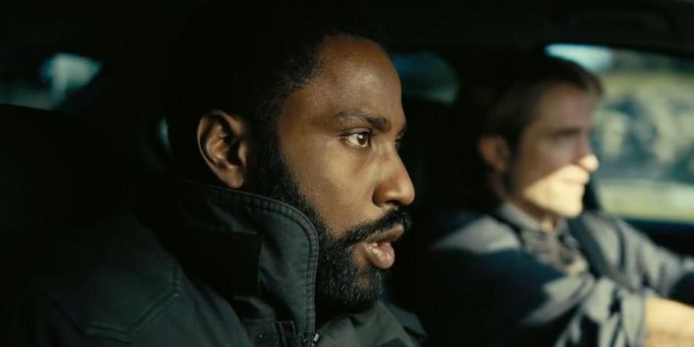 A close-up of Neil, played by Robert Pattinson, driving with the Protagonist, played by John David Washington next to him in the passenger seat in 'Tenet'