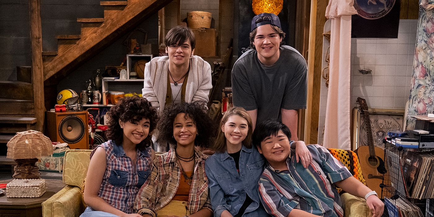 The cast of That '90s Show sitting on the couch in the iconic That '70s Show Forman basement.