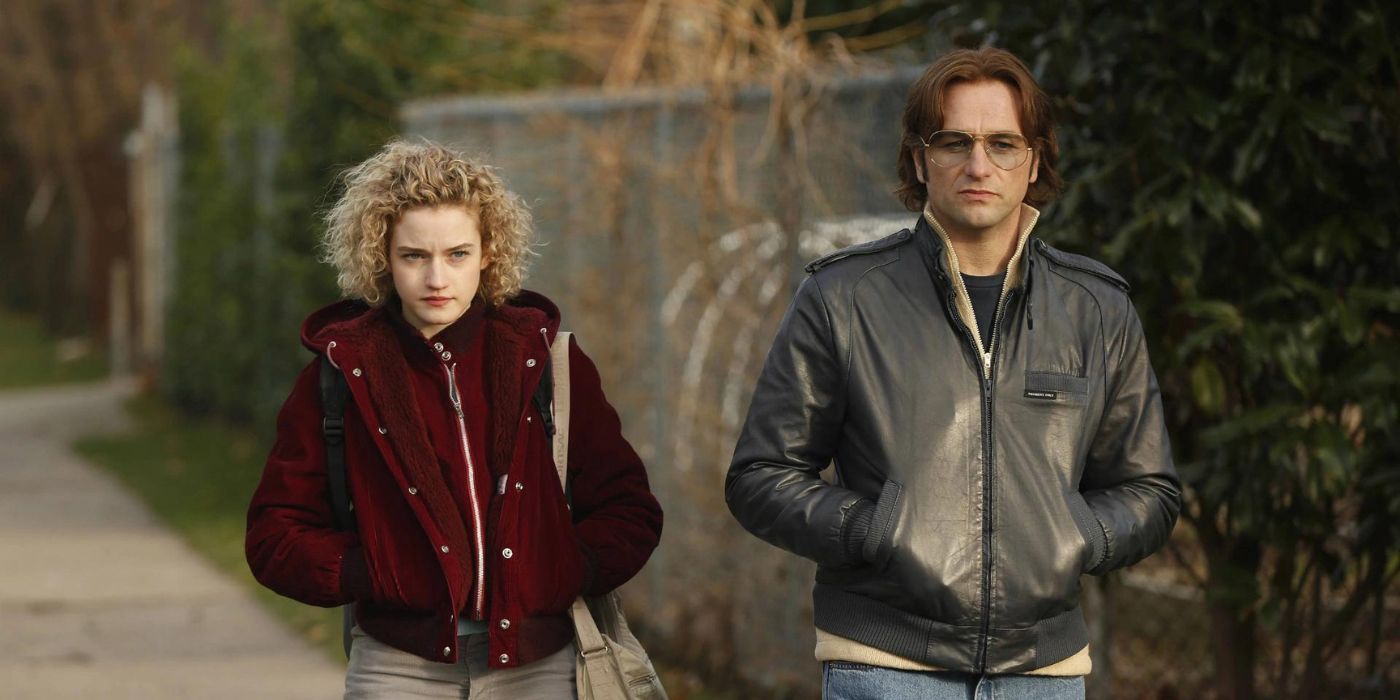 Kimberly, played by Julia Garner, walks down the sidewalk next to Phillip, played by Matthew Rhys, who is in costume from 'The Americans'.