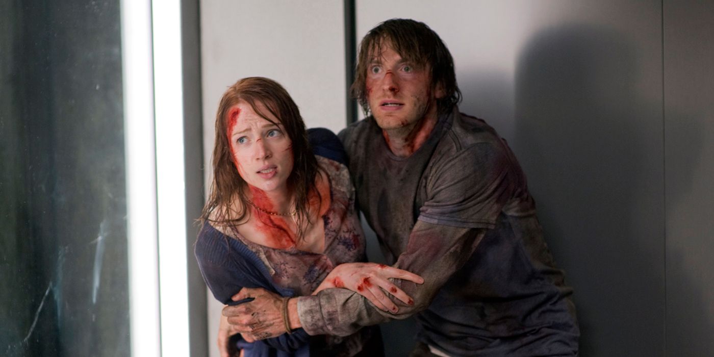Kristen Connolly as Dana and Fran Kranz as Marty covered in blood and holding each other in The Cabin in the Woods.