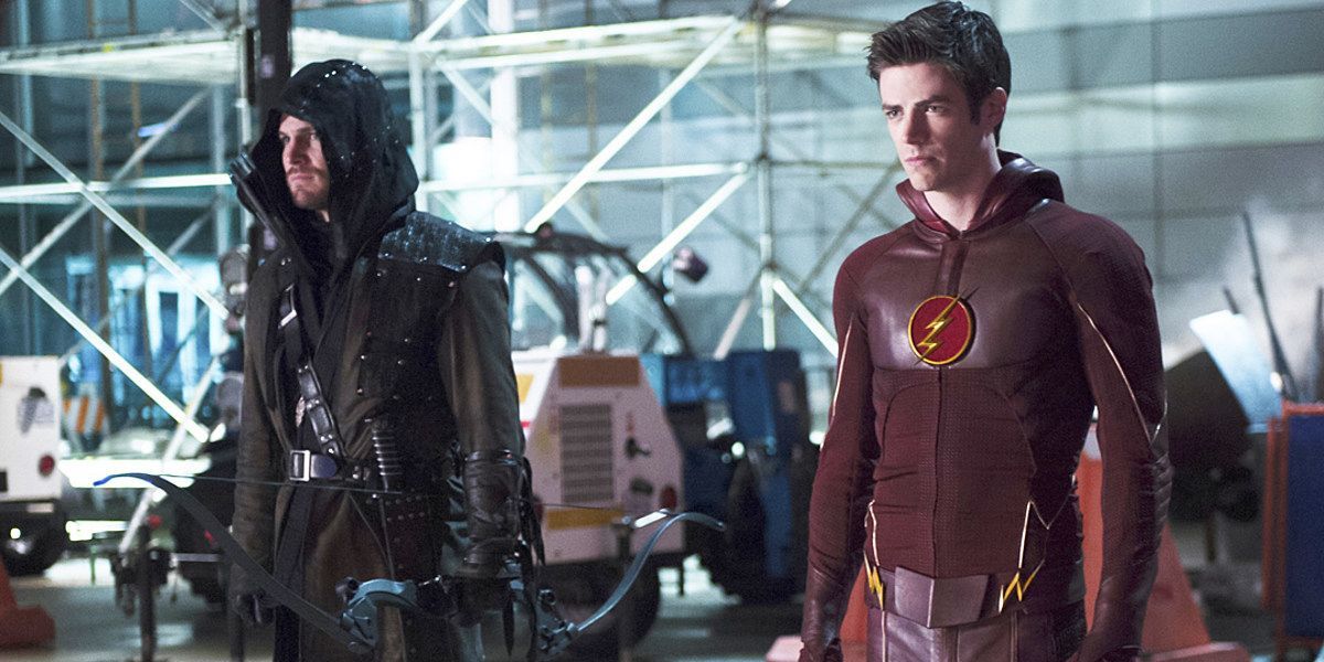 Stephen Amell as Oliver Queen/Green Arrow standing next to Grant Gustin as Barry Allen/The Flash, both suited up for battle in the Arrow Season 3 crossover event.