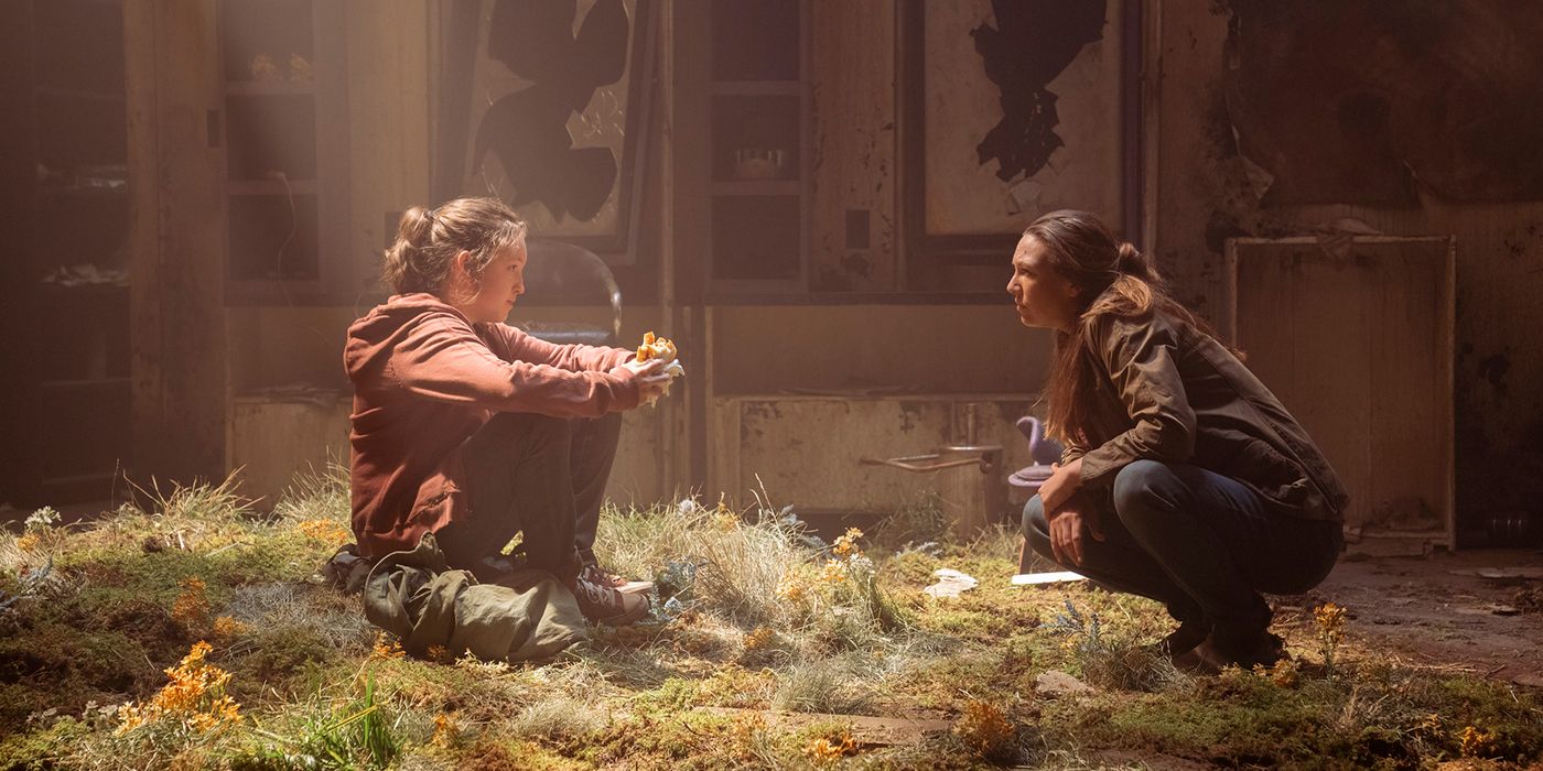 Tess makan sandwich sambil berbicara dengan Tess di sebuah bangunan terbengkalai dalam sebuah adegan dari The Last of Us.
