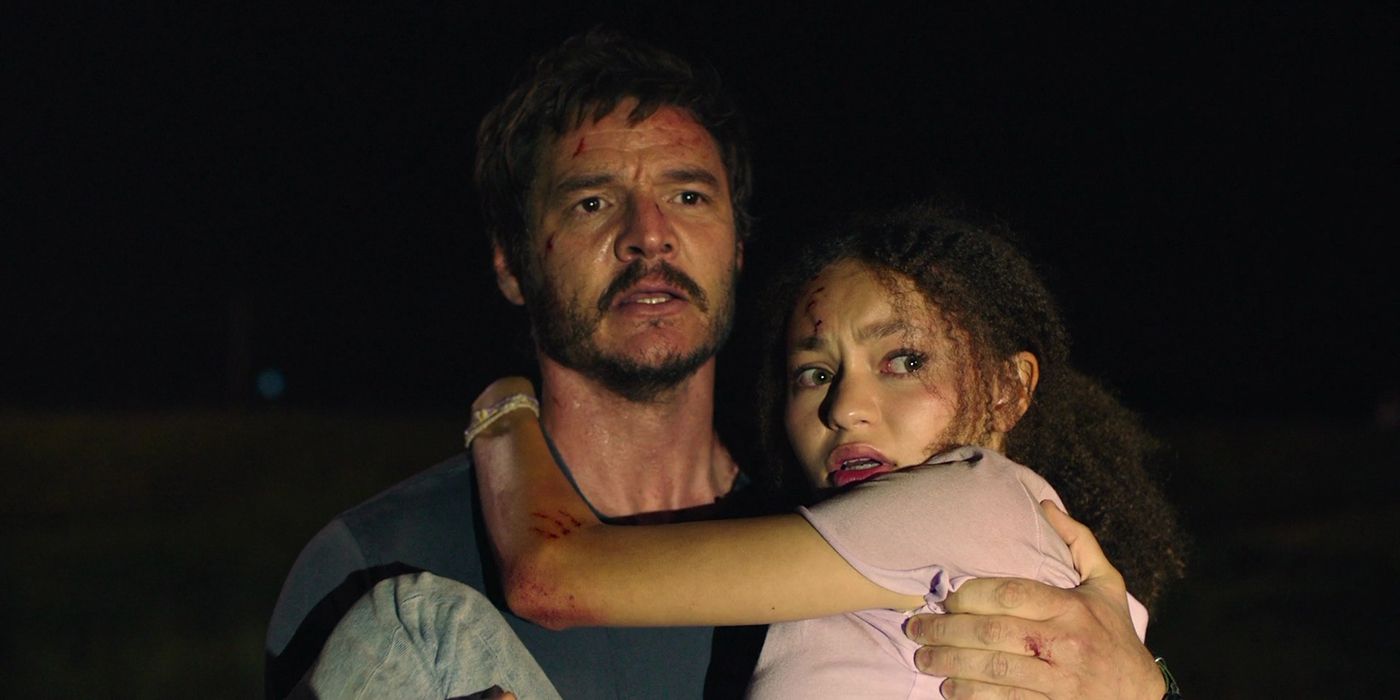 Pedro Pascal as Joel carrying a scared Sarah in The Last of Us.